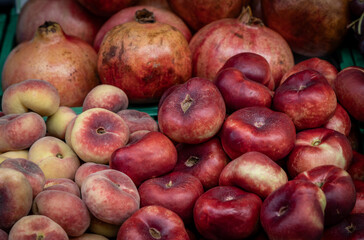 A display of donut, or flat, nectarines and peaches.
