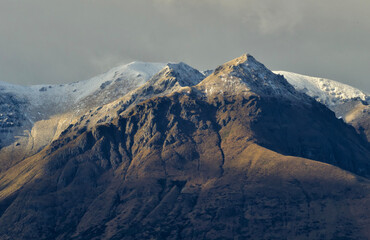shadows on the mountains covered with a light snow