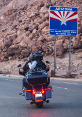 Motorcycle trip across America. Couple of bikers rides along the highway against the backdrop of rocks, rear view. Unrecognizable bikers on a motorcycle