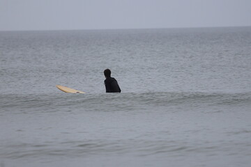 Surfers on the beach and in the ocean mid-morning. Jacksonville, Florida.