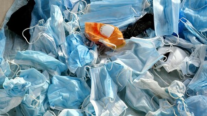 Used medical masks. Covid-19 waste. Concept of plastic pollution of the world's oceans and...