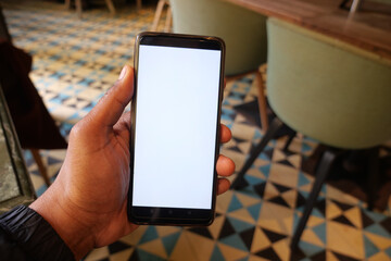 young man hand using smart phone with white screen at cafe 