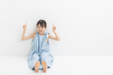 ハンドサインをするワンピースを着た女の子