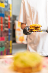 Chef carrying a stack of hamburger patties for the hamburger bun