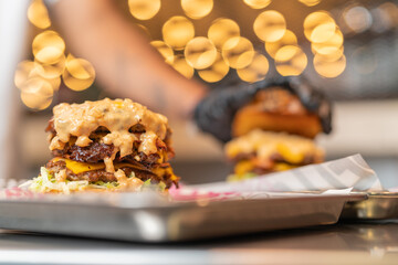 Assembling cheeseburgers with sauce in the restaurant