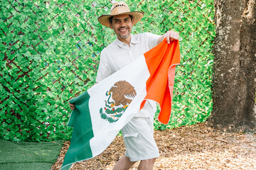 Smiling Man Holding Mexican Flag in Garden