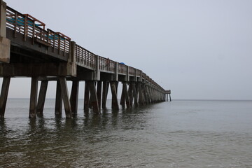 Obraz premium Boardwalk and pier on the beach across the ocean mid-morning. Jacksonville, Florida.