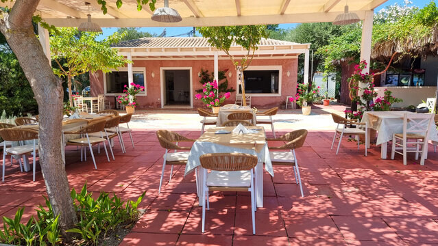 restaurant in greece corflu island tables chairs undrer trees by the  sea