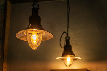 Two Light Bulbs Hanging From Ceiling, Representing Rising Electricity Costs and Creative Solutions