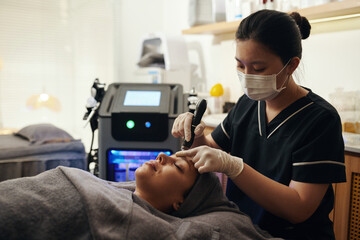 Cosmetologist using micropen for micro needling procedure to reduces fine lines and wrinkles