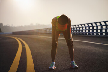Fitness woman runner running on seaside bridge