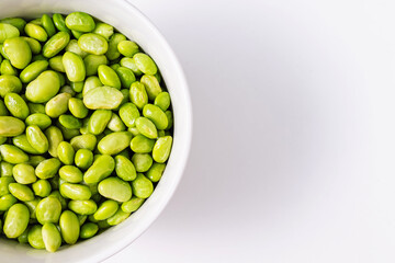 Green steamed soybeans, shelled edamame in a bowl close-up