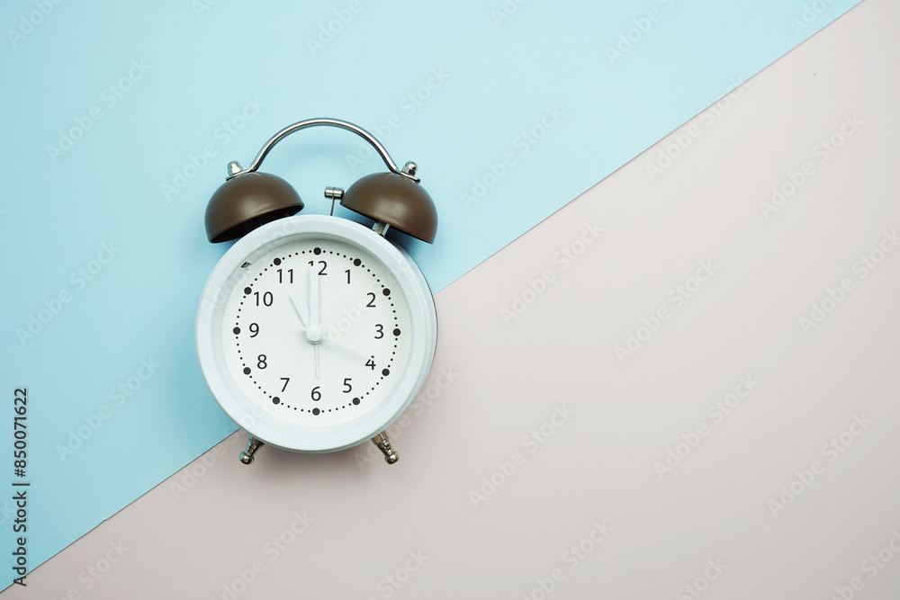Poster top view of alarm clock with space copy flat lay on blue and pink background