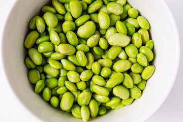 Green steamed soybeans, shelled edamame in a bowl close-up