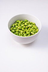 Green steamed soybeans, shelled edamame in a bowl close-up