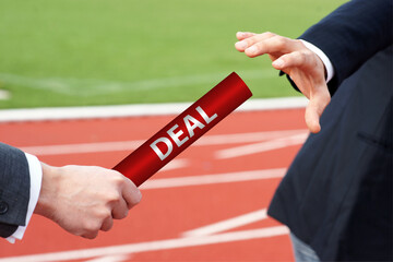 Business deal baton handover in relay race race