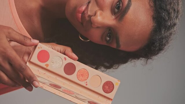 Young attractive model showing a set of cosmetics