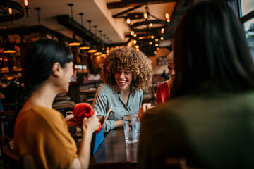Fototapeta premium Female friends sitting in the cafe and chatting about new clothes that they bought. Women and shopping concept