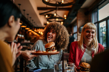 Waiter serving food to a group of customers at a restaurant 