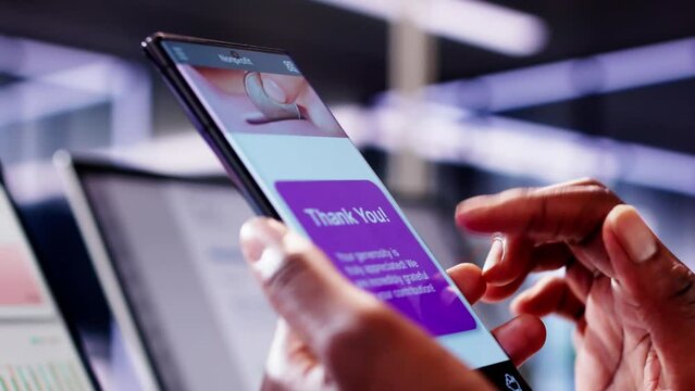 African American woman using smartphone app to donate money online