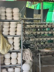 Showcasing an array of unfinished pottery ceramic pieces, meticulously arranged on workshop...