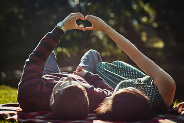 Couple, relax and heart for love in outdoor with partnership, commitment and support of romance wellness. People, peace and connection with trust icon, hope and adventure together in vacation date