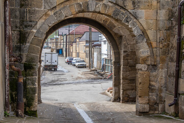 Obraz premium An arched passage into the ancient city. An ancient passage to the territory of the fortress. The arch is made of large blocks of stone.
