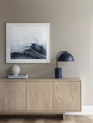 Minimalist picture, frame on the wall with a framed poster of black watercolor waves, beige sideboard, and navy blue lamp in front of it, Scandinavian interior design, soft light.