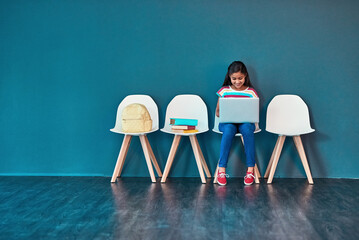 Admission, laptop and learning with girl student in waiting room of school for entrance exam or interview. Chairs, children and computer with education candidate getting ready for academic assessment
