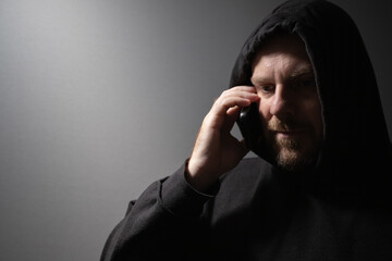 Stalker, a man talking on the phone, cyber crime, internet hacker, hiding from authorities.