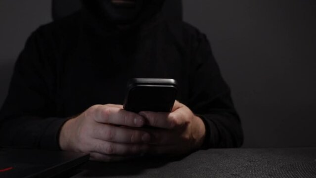 Man in a mask with a phone, robber, bandit, hooligan.