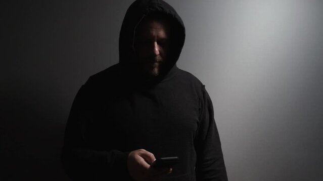 Identity thief, a man with a phone, acting as a hooligan, engaged in a crime, evading capture.