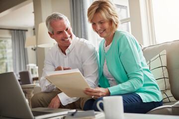 Fototapeta premium Senior couple, paperwork and laptop on sofa with discussion, smile and taxes in home. Old man, woman and computer with documents for compliance, reading and investment report with finance management