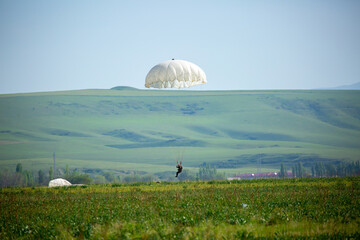 Skydiving. Flying parachutists against the background of the blue sky and mountains. Extreme sport and entertainment.