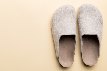 Warm winter women woolen slippers on colored background. Copy space for text