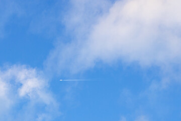 the plane flies in the sky with white cloud. background of airplane flying in the blue sky