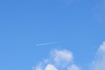 the plane flies in the sky with white cloud. background of airplane flying in the blue sky