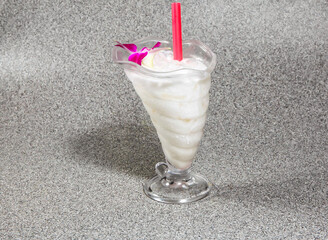 iced coconut milk with straw served in glass isolated on grey background side view of hong kong...