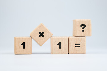 Basic mathematics, one plus one question by toy wooden cubes on white background