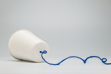 A white paper cup with string as the other end of the line of an old style phone