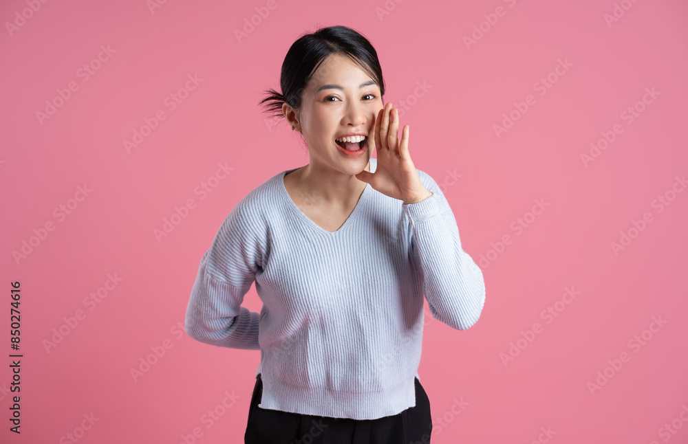 Wall mural Portrait of beautiful asian woman posing on pink background