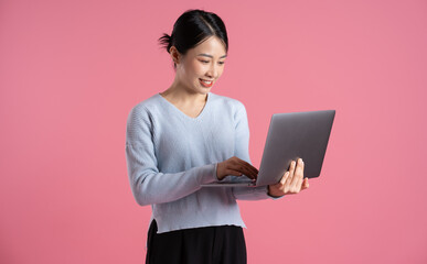 Portrait of beautiful asian woman posing on pink background