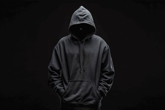 Isolated faceless man in hoodie on black background, symbolizing hacker, thief, dark demon, mysterious creature, Halloween character, secret