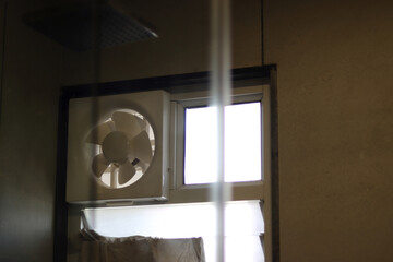Exhaust fan in the modern bathroom with green wall tiles