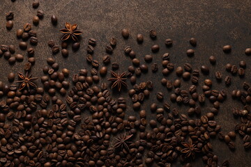 Coffee beans scattered on a textured brown background. View from above. Flat lay