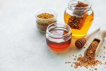 Raw organic bee pollen and honey in jars.