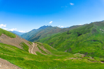 Obraz premium Mountain road leading to the Datvisjvari pass. Mountains covered with green vegetation