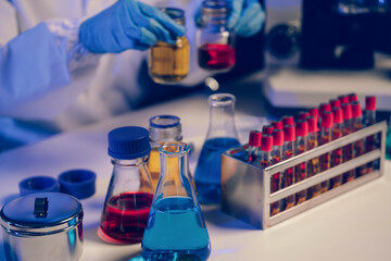 Team of biochemical research scientists working with a microscope for vaccine development in pharmaceutical research labeling.