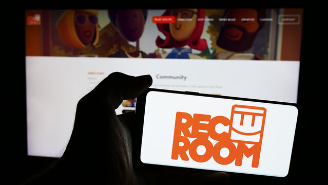 Stuttgart, Germany - 06-01-2024: Person holding mobile phone with logo of American video games company Rec Room Inc. in front of business web page. Focus on phone display.