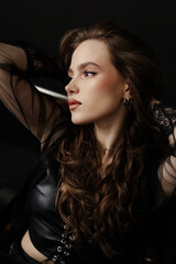 charm of a Gothic muse in these captivating photos, showcasing her intricate piercings and fierce fashion sense. Dressed in a leather vest, she embodies a captivating mix of dark glamour